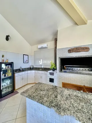 Imagem de uma cozinha com armários brancos e piso de cerâmica.