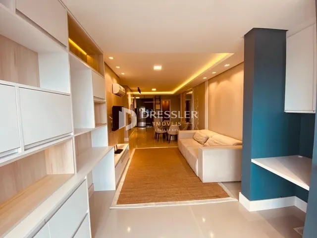Vista interna de uma sala de estar com armários embutidos e piso claro.