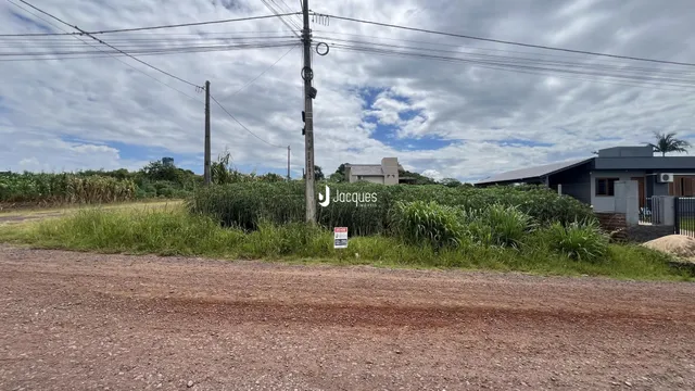 Vista externa de uma propriedade com vegetação densa ao redor.