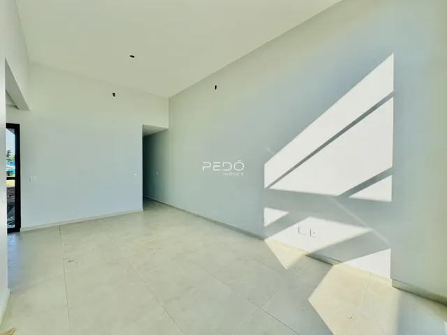 Espaço interno de uma residência com paredes brancas e piso claro.