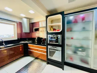 Cozinha com armários de madeira e revestimento de tijolo vermelho.