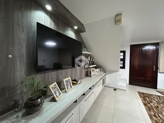 Sala de estar moderna com painel de madeira e televisão.