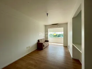 Sala de estar com piso de madeira clara e paredes brancas.