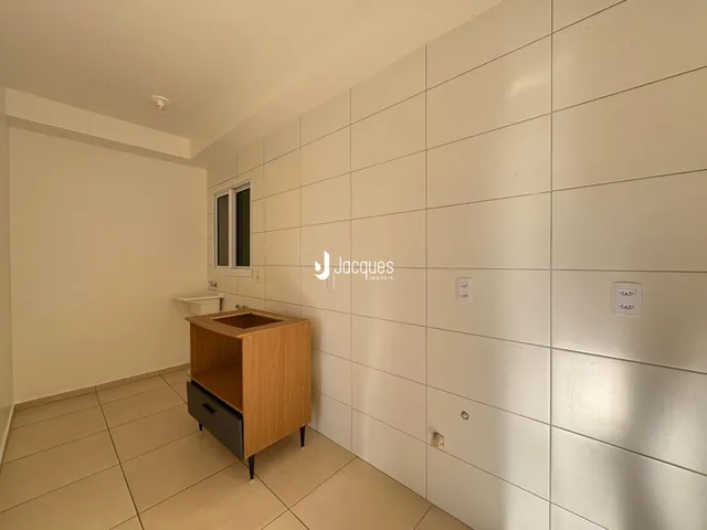 Foto de um ambiente interno com revestimento de parede claro e piso de cerâmica.