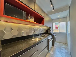 Uma cozinha moderna com armários e bancadas em tons de cinza e vermelho.