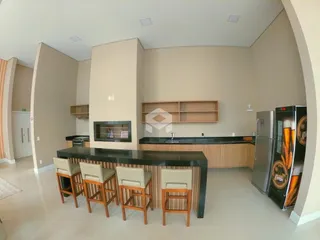 Ambiente interno de uma sala de estar com cozinha moderna em Lajeado.