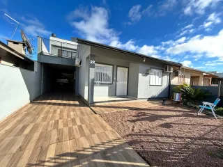 Fachada de uma residência em Lajeado, Brasil, mostrando a área externa com piso de madeira.