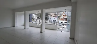 Vista interna de um espaço com paredes brancas e piso de cerâmica.
