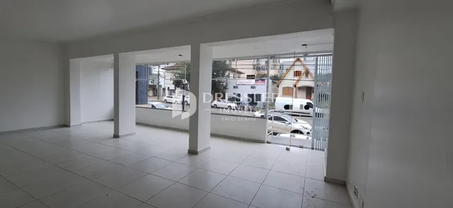 Vista interna de um espaço com paredes brancas e piso de cerâmica.