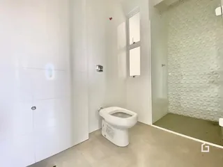 Foto de um banheiro interno com vaso sanitário branco e piso claro.