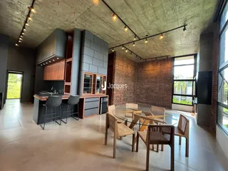 Ambiente de sala de estar e cozinha com parede de tijolos aparentes em Lajeado, Brasil.