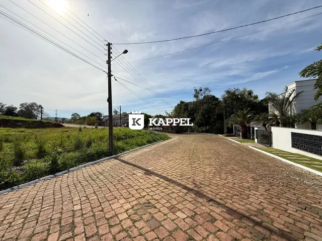 Vista da entrada de uma propriedade em Lajeado, Brasil, mostrando uma estrada de paralelepípedos.