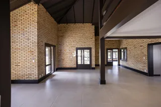 Hall de entrada com paredes de tijolo aparente e piso de cerâmica.