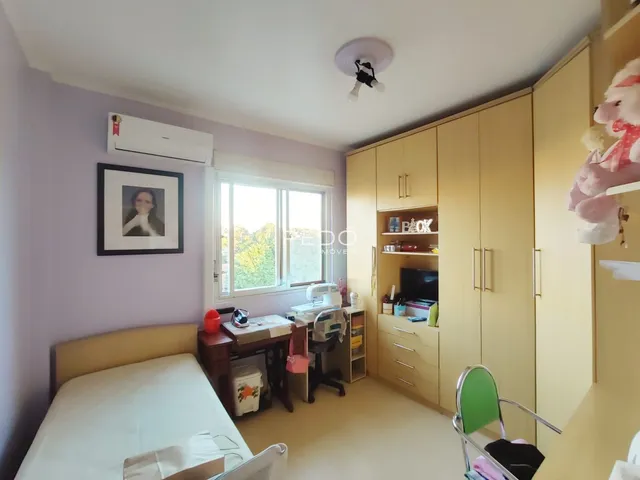 Quarto com armários embutidos e janela em um imóvel em Lajeado.