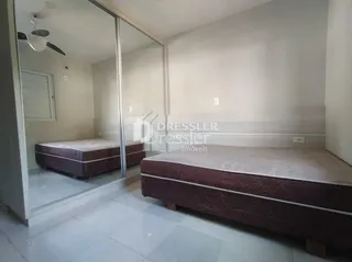 Quarto com cama e divisória de vidro.