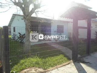Foto da fachada de uma residência em Lajeado, Brasil, com cerca e vegetação no primeiro plano.