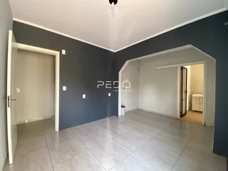 Hall de entrada com piso de cerâmica claro e paredes em tons de cinza e branco.
