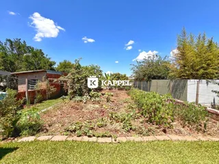 Vista externa de um terreno com vegetação e cerca.