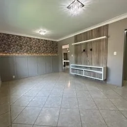 Foto de um ambiente interno amplo com piso de cerâmica e parede texturizada.