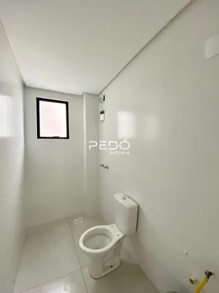 Foto de um banheiro interno branco com piso claro.