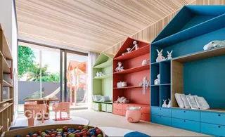Sala de estar moderna com estantes coloridas e piso de madeira clara.