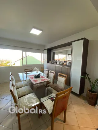 Uma sala de jantar com mesa de vidro e cadeiras de madeira.