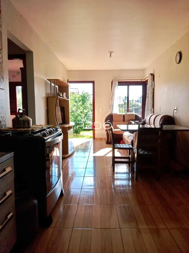 Sala de estar com piso de madeira e porta de entrada.