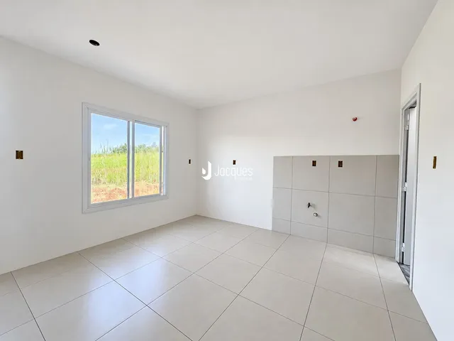 Ambiente interno de uma sala com piso de cerâmica e grande janela.