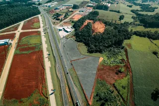 Vista aérea de uma área rural com campos agrícolas e estradas.
