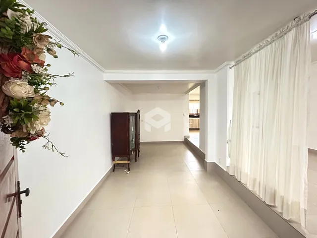 Hall de entrada com piso claro e paredes brancas.