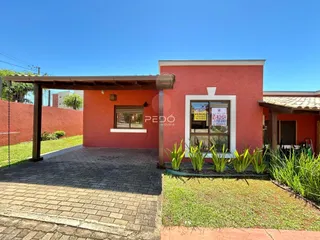 Fachada de uma casa vermelha com garagem e jardim em Lajeado, Brasil.