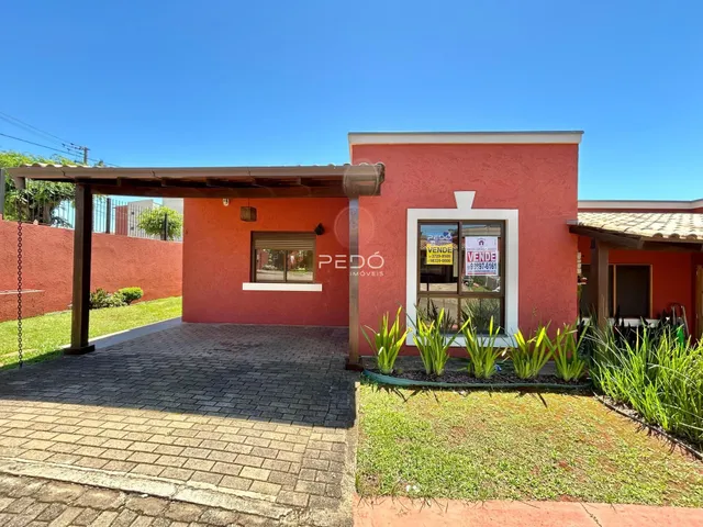 Fachada de uma casa vermelha com garagem e jardim em Lajeado, Brasil.