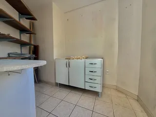 Interior de um ambiente com paredes brancas e piso de cerâmica.