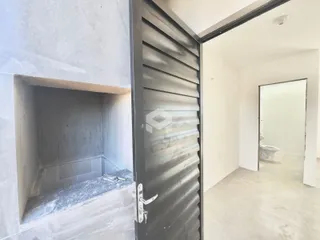 Vista interna de uma passagem entre cômodos com uma porta de metal.
