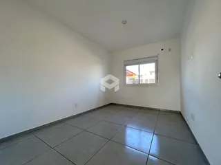 Foto de um cômodo interno com paredes brancas e piso de cerâmica.