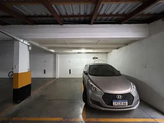 Foto de uma área interna com um carro estacionado em um pátio.