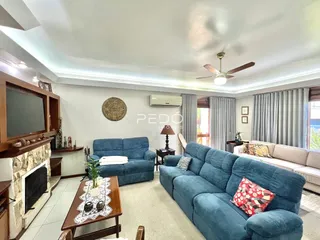 Sala de estar com sofá azul e lareira em um imóvel no Brasil.