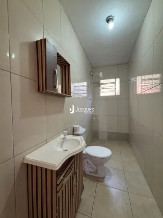 Foto de um banheiro com revestimento cerâmico nas paredes e piso.