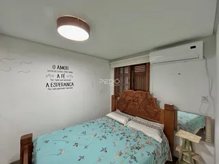 Quarto com cabeceira de madeira e cama decorada em azul claro.