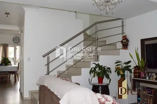 Foto de um interior mostrando uma escadaria e uma cama em uma residência.