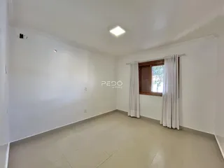 Ambiente interno de uma sala ampla com paredes brancas.