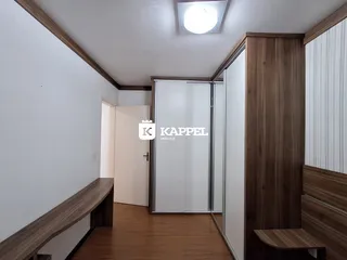 Foto de um corredor interno com piso de madeira e painéis de madeira.