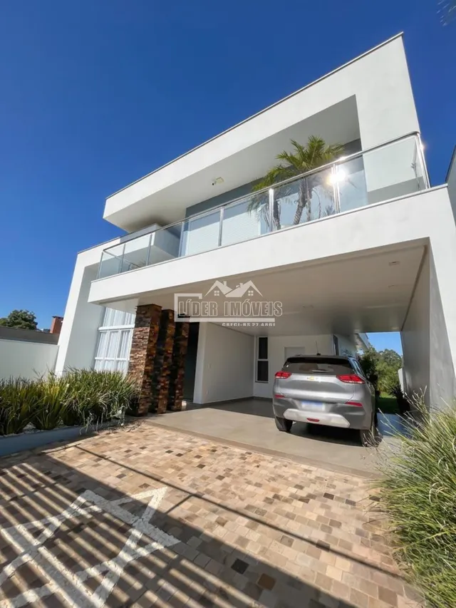 Fachada moderna de uma casa em Lajeado, Brasil, com varanda e área pavimentada.