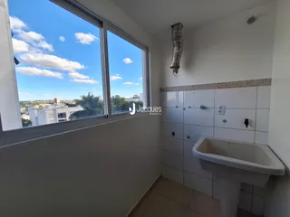 Banheiro com janela ampla oferecendo vista da paisagem urbana.