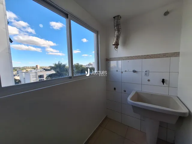 Banheiro com janela ampla oferecendo vista da paisagem urbana.