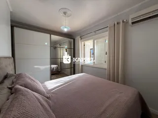 Quarto com cama grande e armário branco.