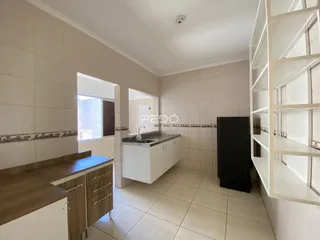 Imagem de uma cozinha com piso de cerâmica clara e paredes brancas.