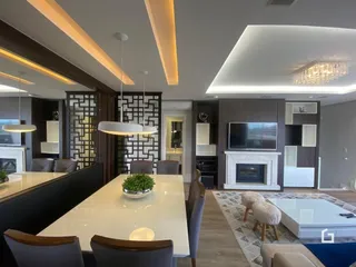 Sala de estar moderna com mesa de jantar e lareira.