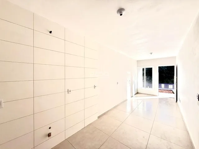 Hall de entrada com paredes brancas e piso claro.