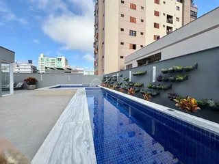 Foto de uma piscina externa em um terraço com vista para um edifício residencial.